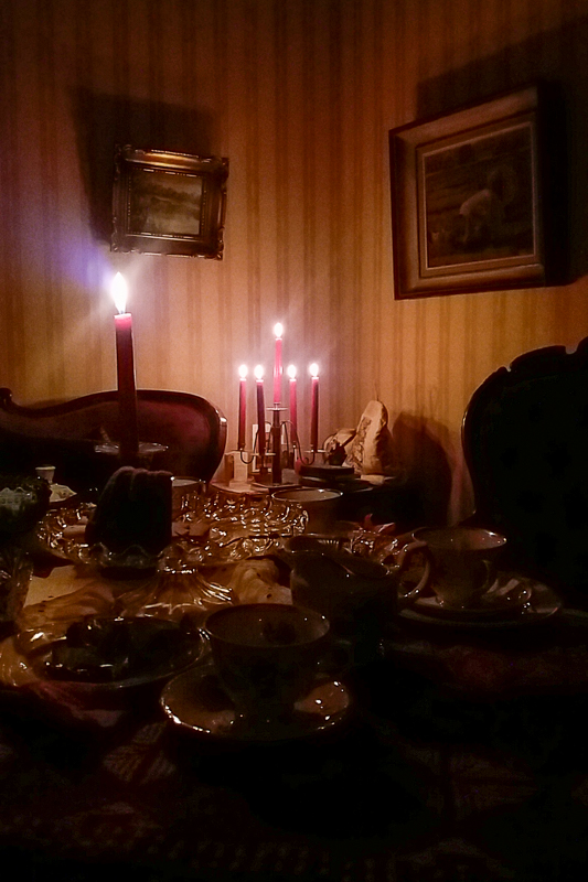 Salikamari, jossa kynttilät palamassa ja kahvitarjoilu pöydälle katettuna.